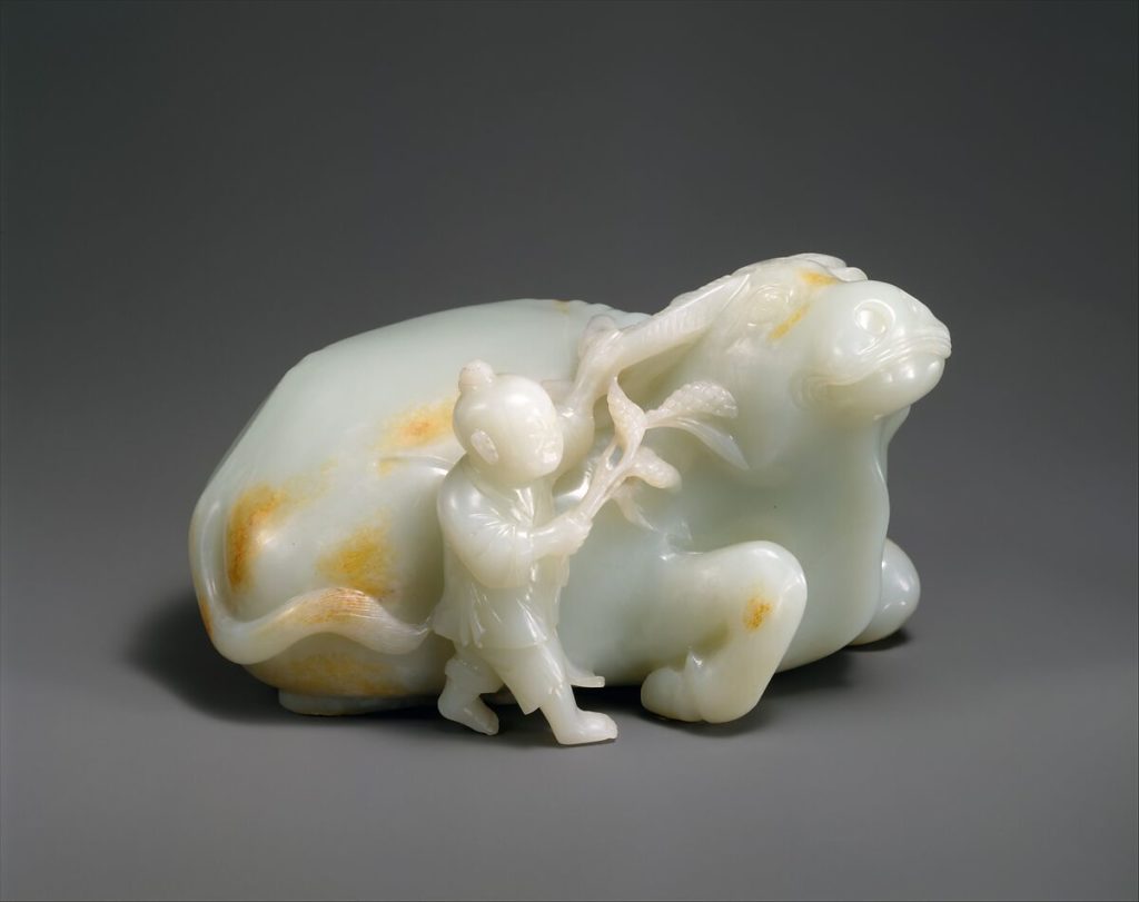 A Qing Dynasty carving, from the 18th century, of a boy with a water buffalo made with white nephrite.