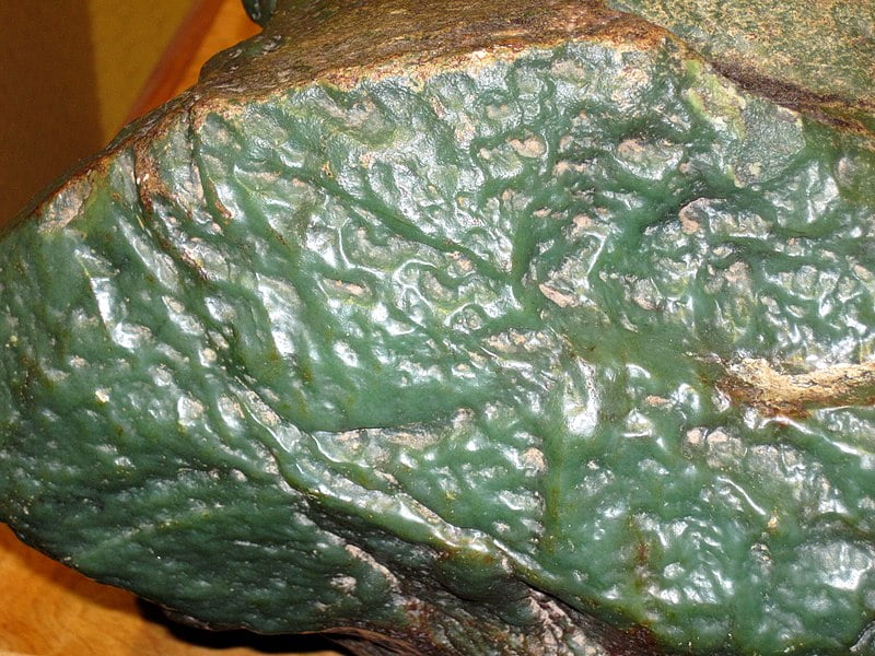 A good example of nephrite vs jadeite. This jade is nephrite, not jadeite, showing a waxy luster very evident from the photo. Jadeite does not have this waxy or greasy look to it.